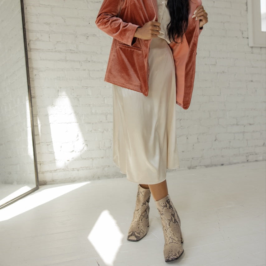 This skirt is made from strength and stardust. Drape this flattering and classic slip skirt on and you'll be ready for anything. Featuring an elastic waist, side zipper, and silky material.