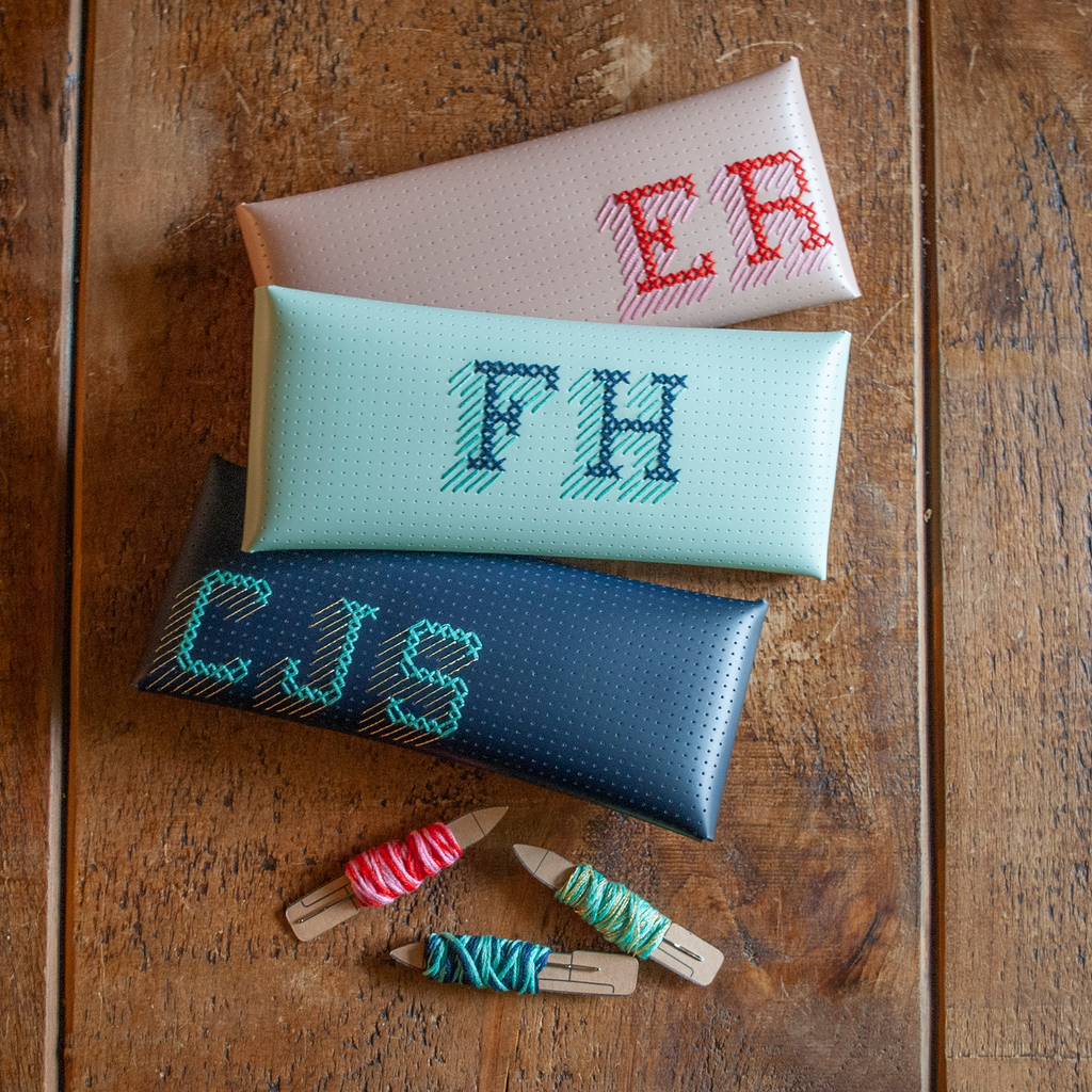 Stitch your own way - this envelope pocket is ideal as a pencil or glasses case and allows you to sew any unique design. Whether you stitch initials, a slogan or the sunglasses template included, it opens out fully for easy stitching. It also opens 2 ways, so it can open from the side or from the top - just pop the metal buttons to fold up whichever way you prefer. The Navy pouch comes with teal & gold thread &amp; needle wrapped on our pen thread-board. It includes our 3D alphabet template to add initials