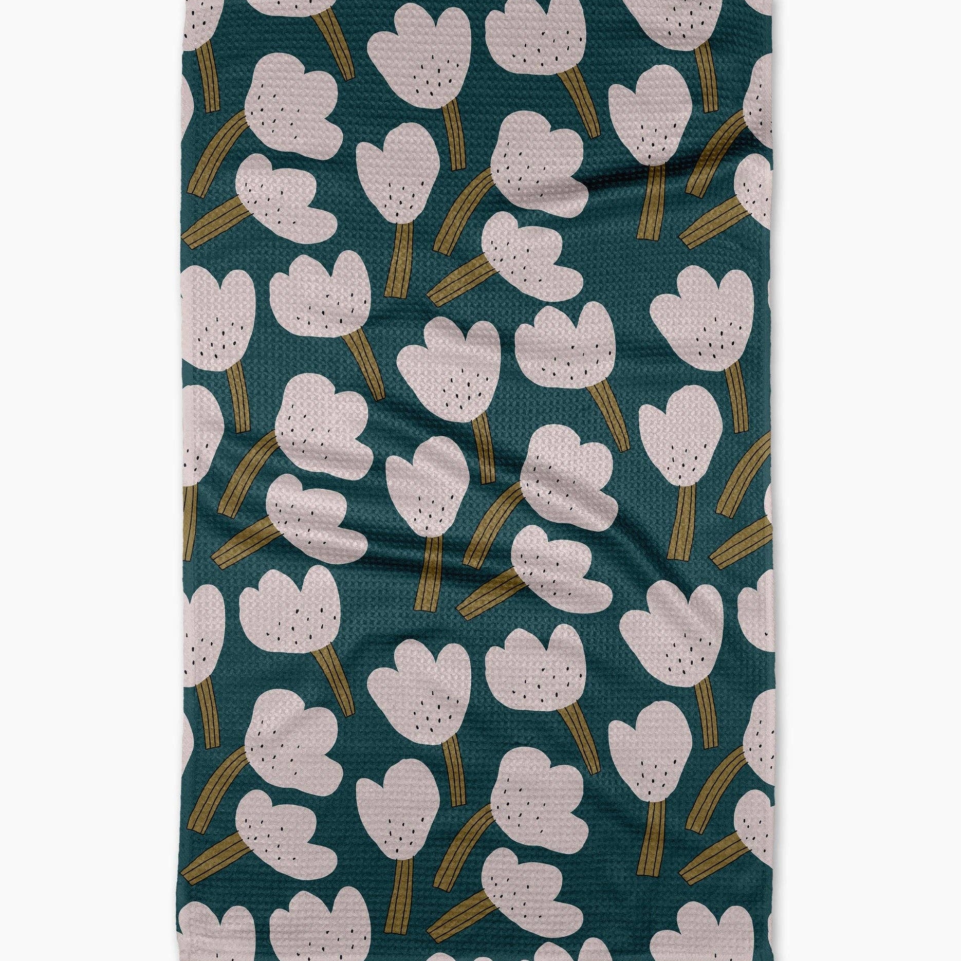 white  tea towel  floral pattern on a teal background hanging against a plain wall.