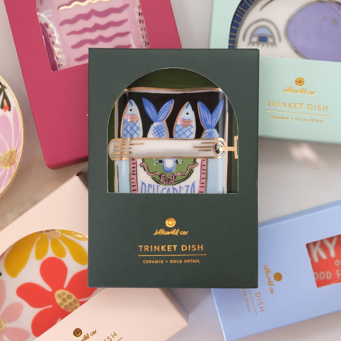 A fan favorite giftable–Our ceramic trinket dishes are the perfect catchall for your nightstand or dresser. White ceramic is adorned with our colorful, hand-painted designs, and we lined the edge in 10k gold for added flair. Perfectly packaged in plastic-free gift boxes, pretty enough to give without wrapping!

• 3″ x 3″ Dish

• Ceramic with 10k Gold Detailing

• Plastic-Free Gift Box