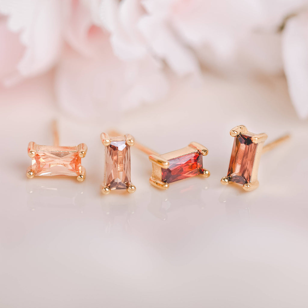  Birthstone Ombre Baguette Stud Earring Set, a collection of four stunning earrings crafted in 18k gold plated with an anti-tarnish coating. This set of stud earrings showcases the ombre effect, seamlessly blending hues from light to dark, creating a captivating visual representation of your birthstone's color spectrum. 