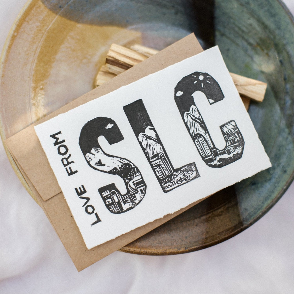 4x6 hand carved and pressed black and white card reading "LOVE FROM SLC" with the city skyline
