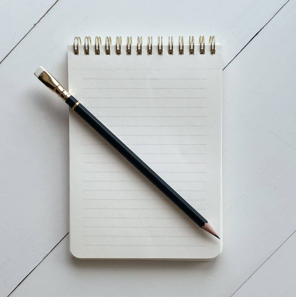Notebook with a pencil on a light gray surface