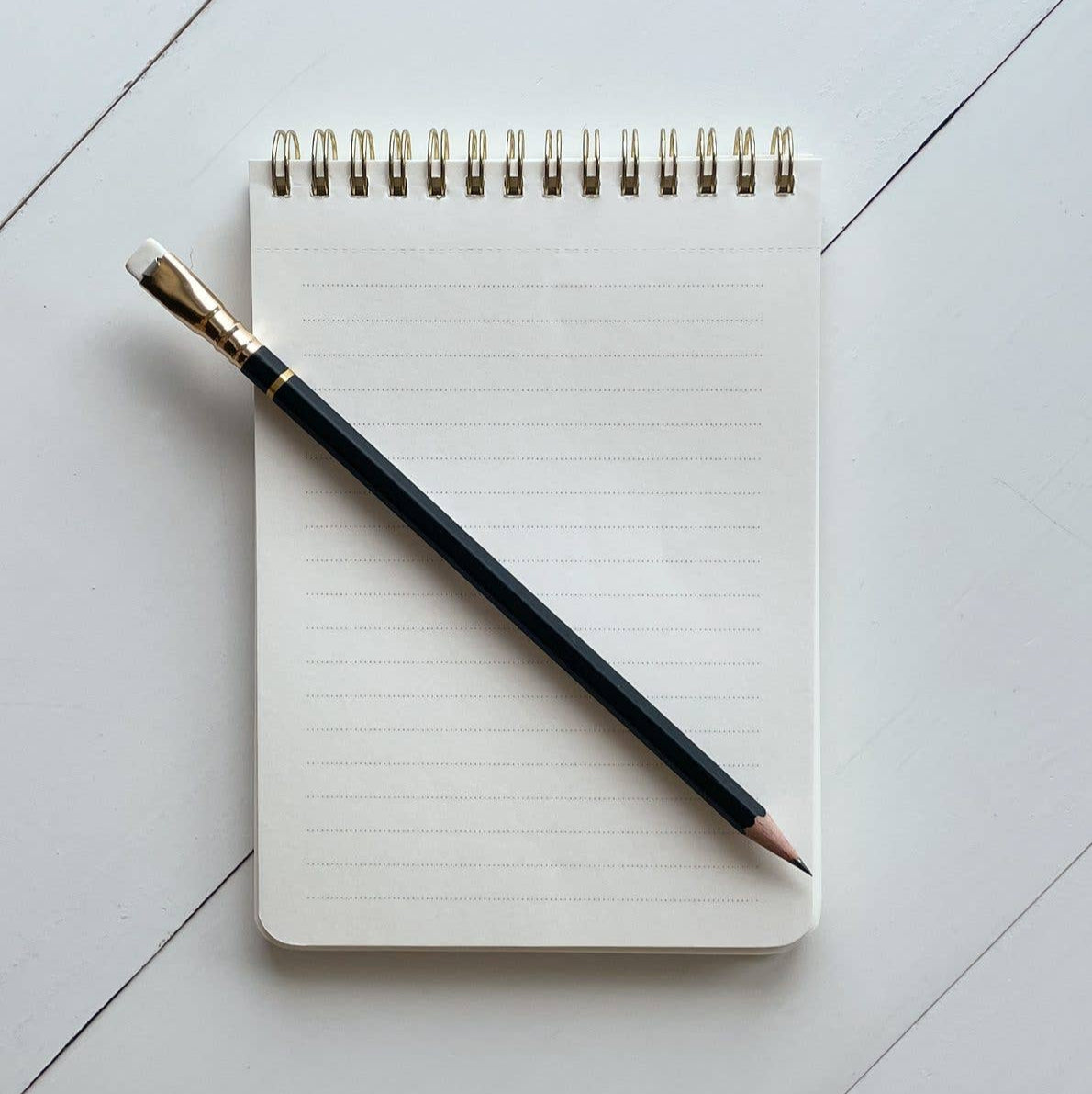 Notebook with a pencil on a light gray surface