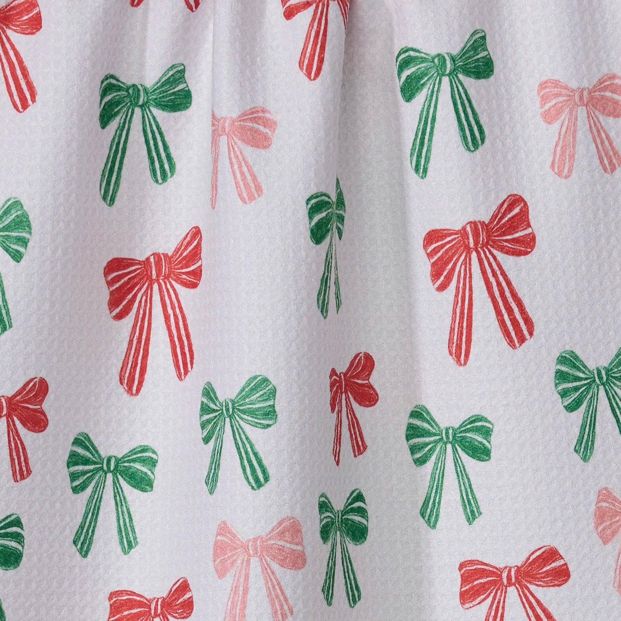 Pattern of red, green, and pink bows on a white background