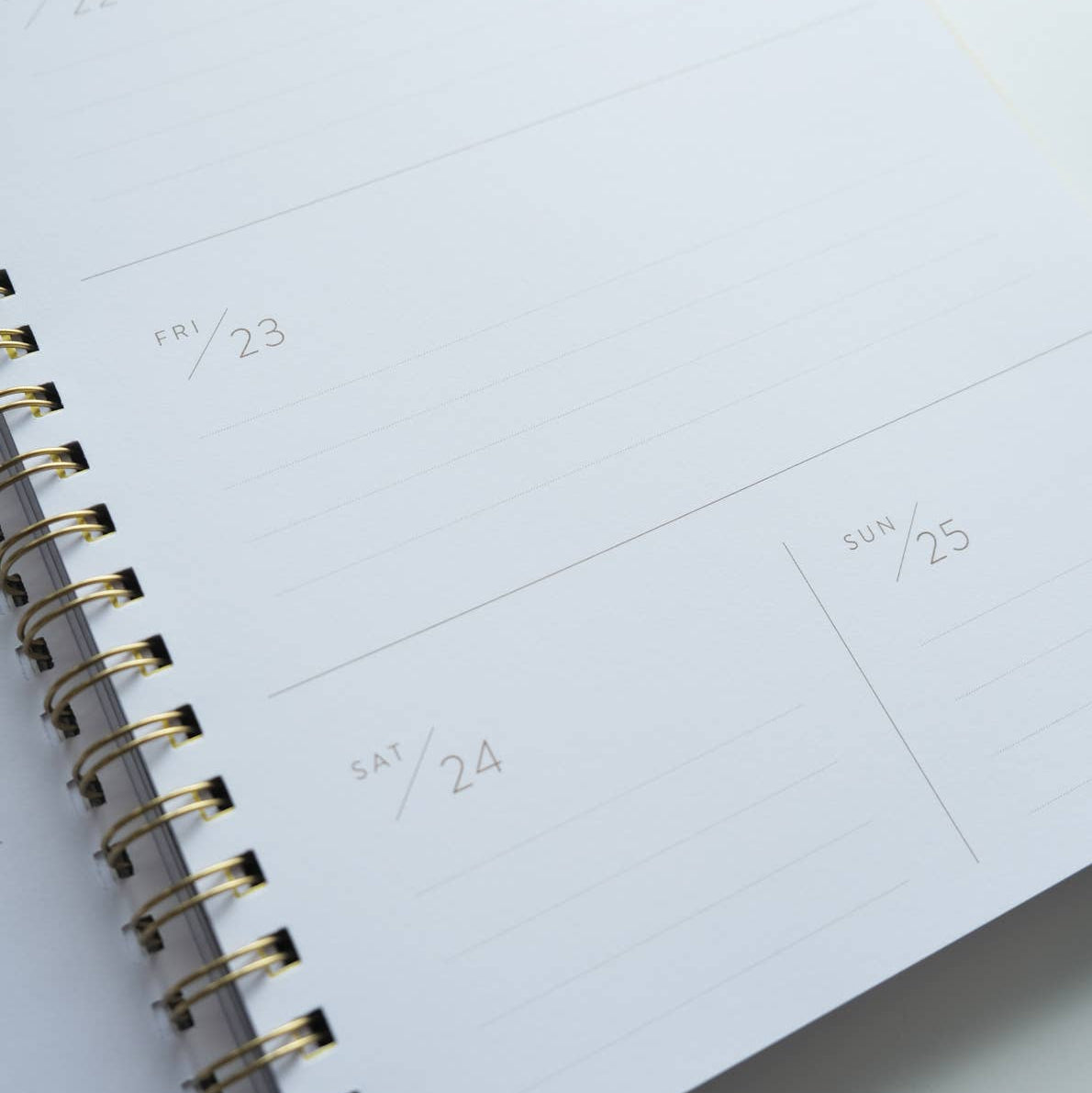 Close-up of a spiral-bound planner with a calendar layout on white paper.