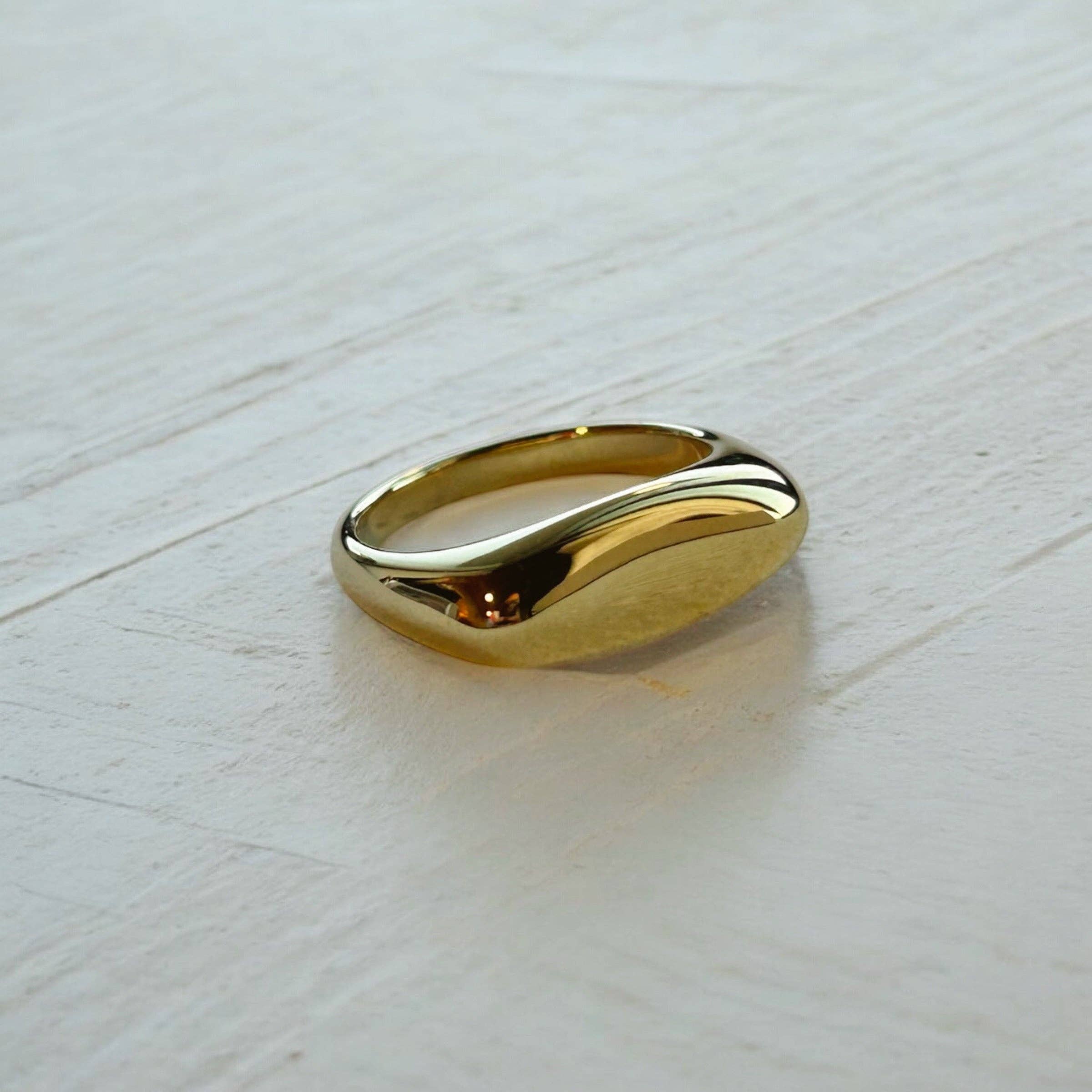 Gold ring on a light wooden surface