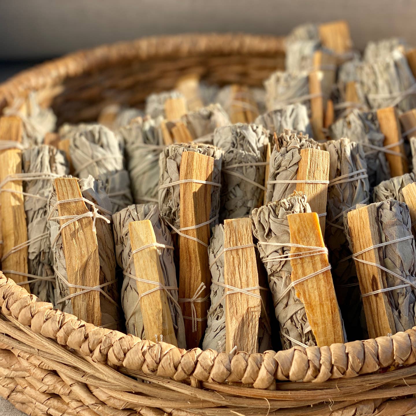 Bundles of incense sticks tied with twine in a woven basket