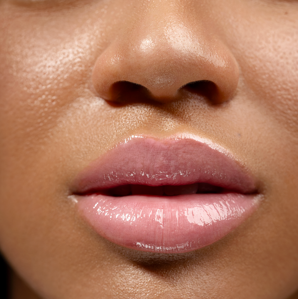 Close-up of a woman's lips with pink lipstick on a blurred background