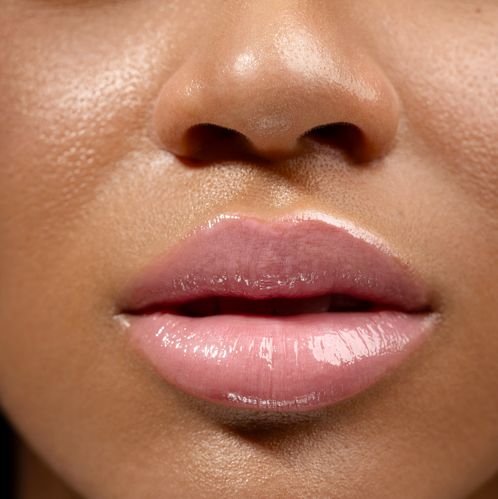 Close-up of a woman's lips with pink lipstick on a blurred background