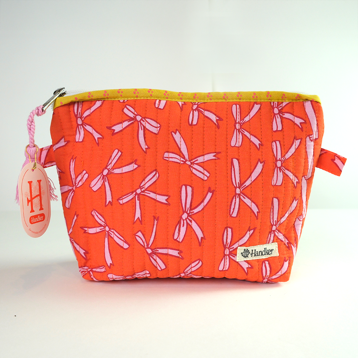 Orange pouch with pink bow pattern on a white background