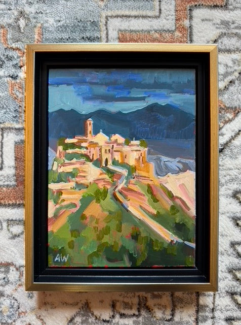 Dusk over an Italian villa. The sun is shining on the mountain and in the background there are blue mountains. 
