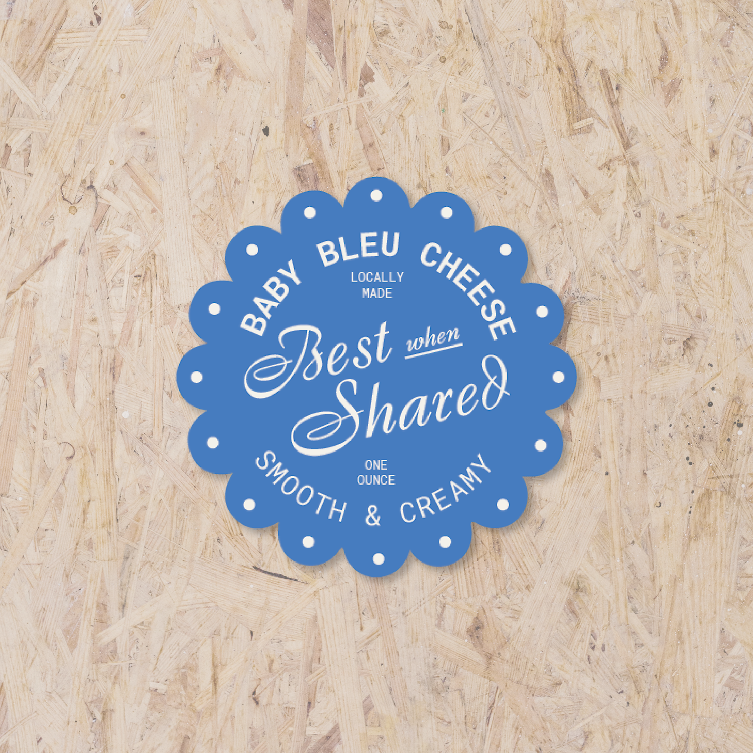 blue scalloped circle sticker reading "Baby bleu cheese, locally made, best when shared, one ounce, smooth & creamy"