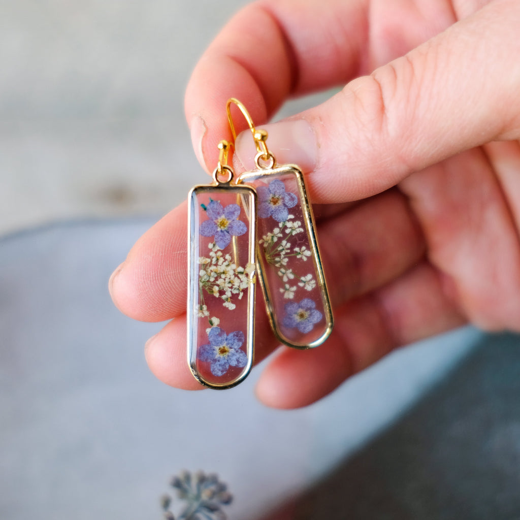 blue hand pressed forget me not flower earrings in gold rounded rectangle bezels 