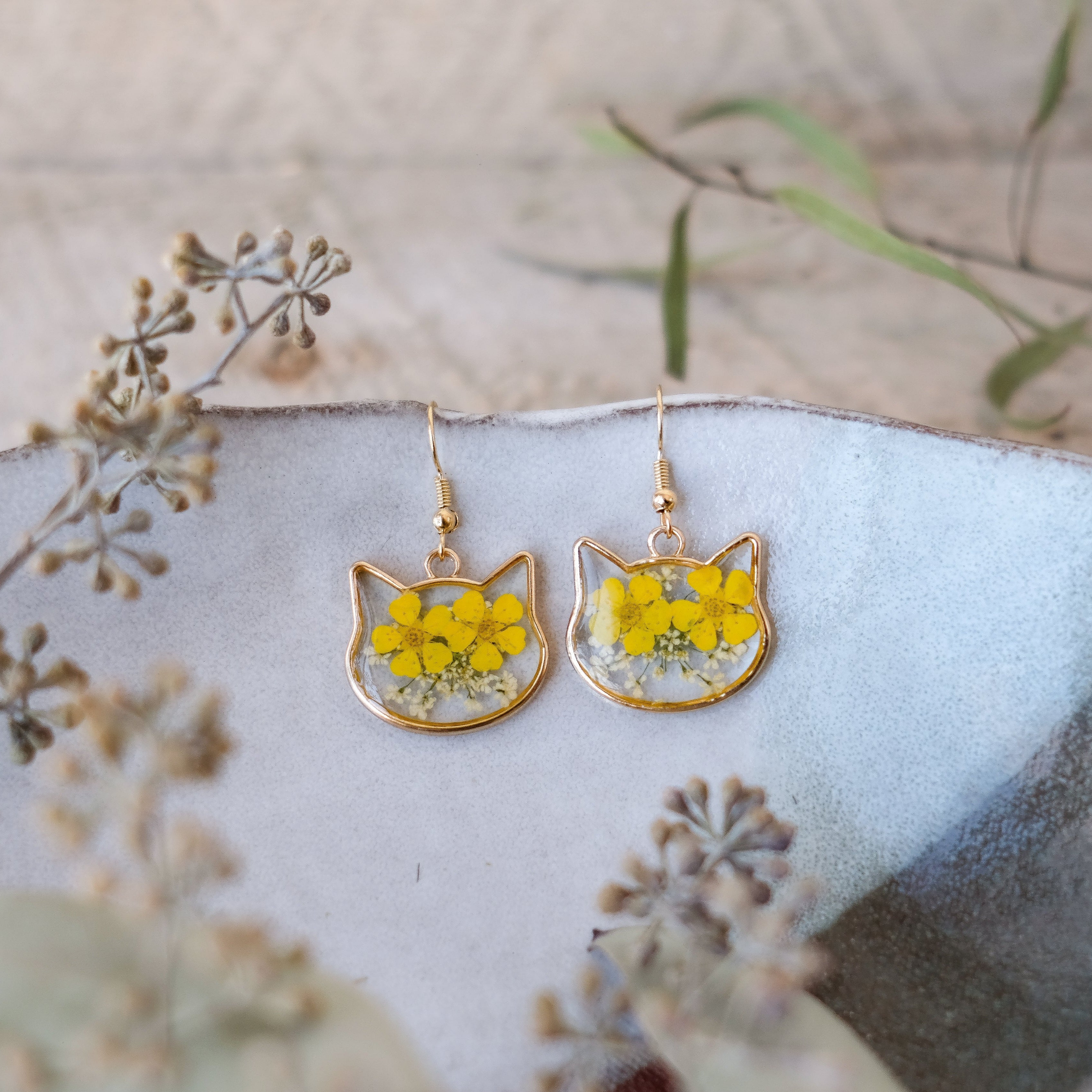gold, cat shaped earrings with yellow hand pressed flowers