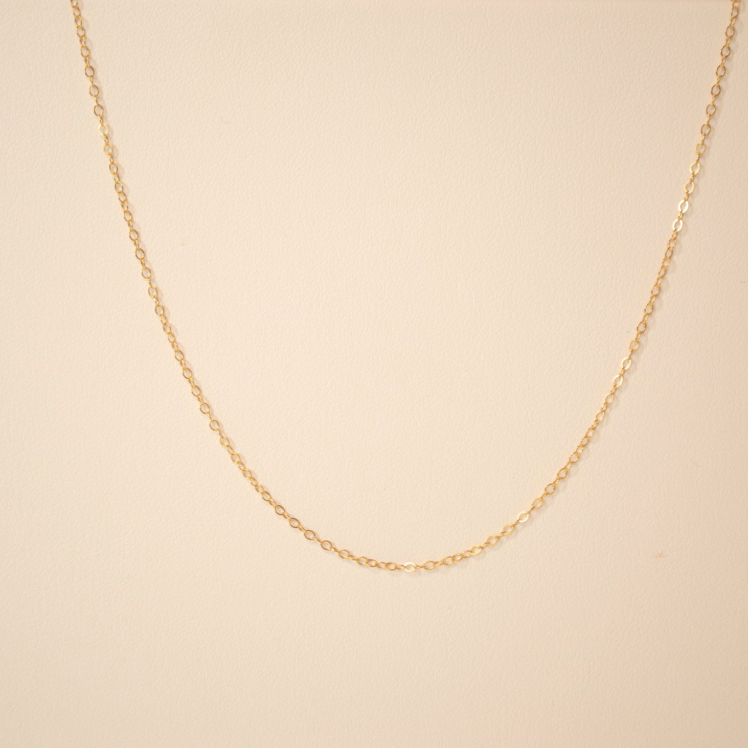 Gold chain against an off white back ground.