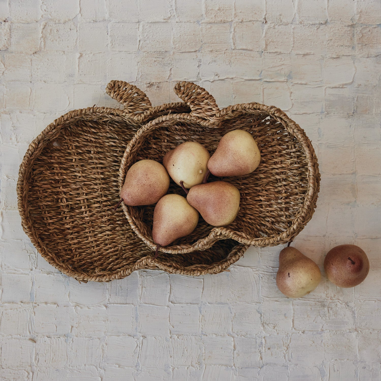 Wicker apple-shaped basket with pears on a textured surface