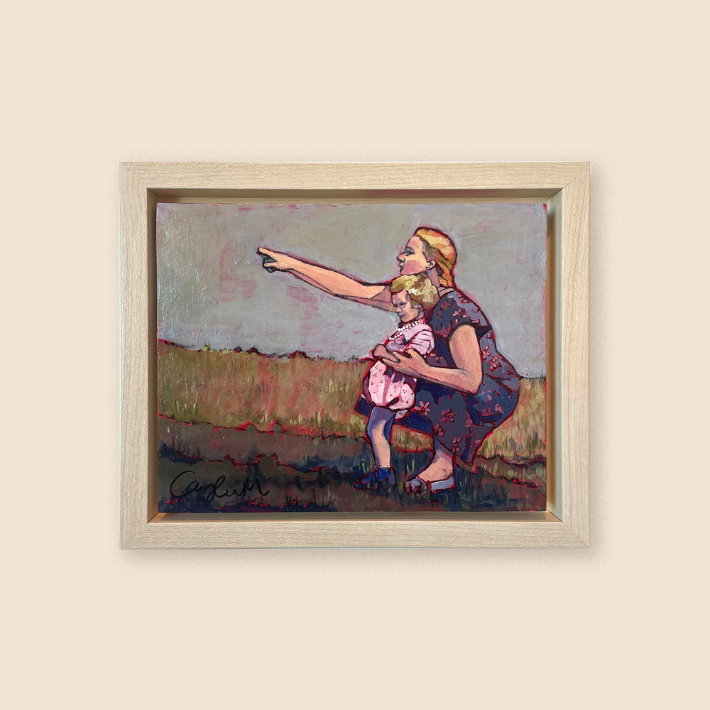 A mother crouches behind her young child, pointing at something in the distance. The mother is wearing a purple dress with a pink floral pattern and her hair is blonde, and her daughter, with curly blonde hair, is wearing a pink dress with a pearl necklace. It's a little windy and their skirts are moving as the field of golden knee-high grass fills the landscape behind them. 