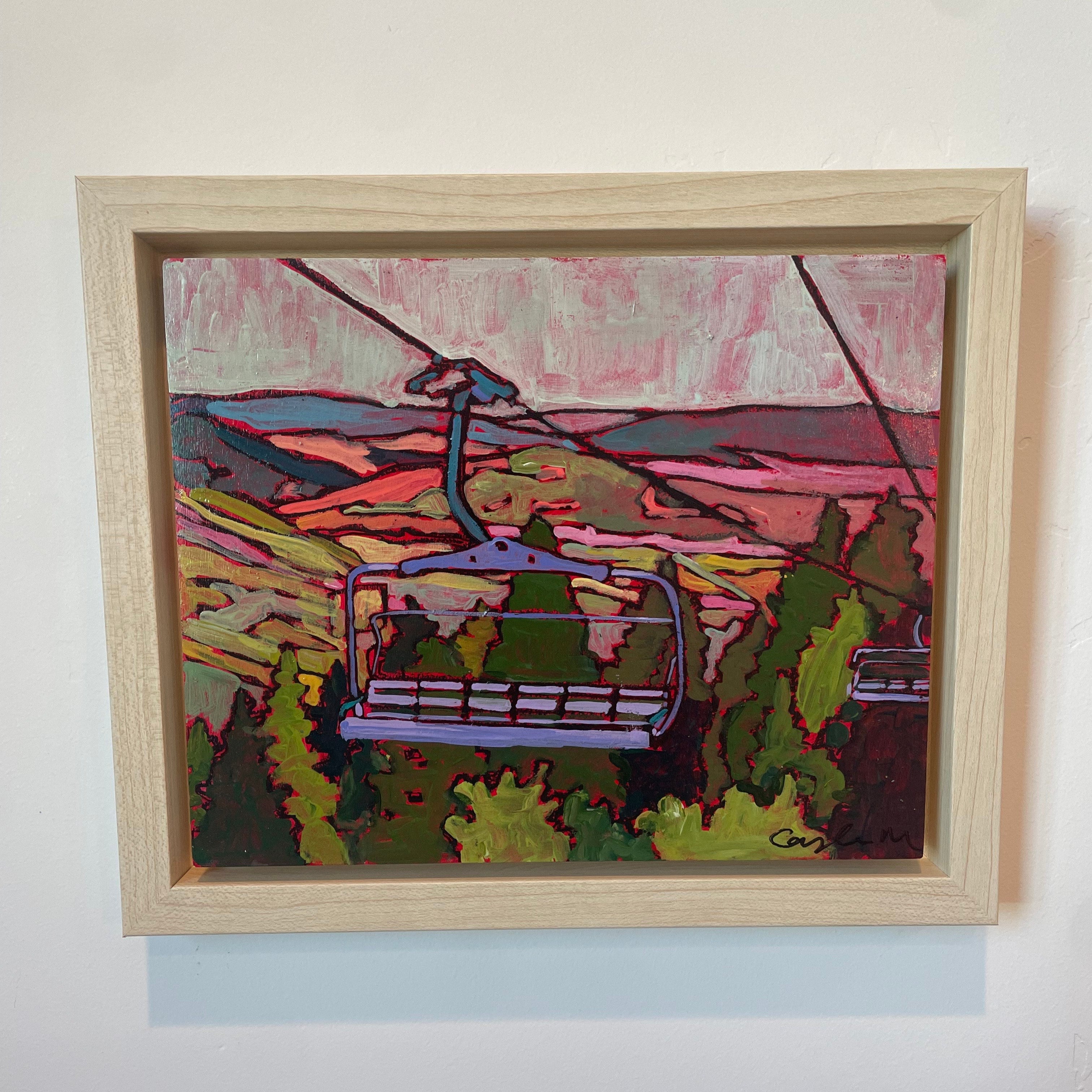 Looking down as if you are standing on the mountaintop, you see a ski lift close in the foreground and a second ski lift slightly out of frame in the backgroun. The mountains and valleys are hues of bright pink and purple with shades of green and leafy trees below. It is dusk and the sky is blue and purple. 