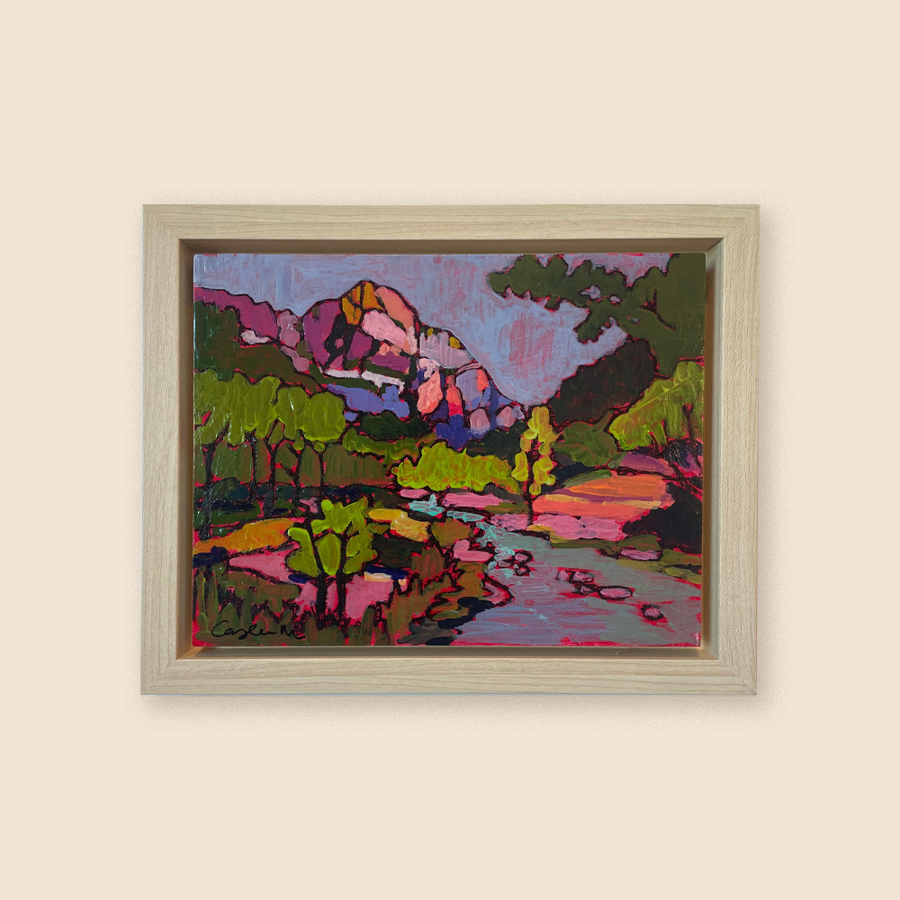 A bright pink and moody colored river fading into a mountainscape with leafy trees surrounding. The artist has taken creative liberty using hot pink, dark blue, orange, and light pink to color the land and mountain where normally you would see greens and greys and browns. 