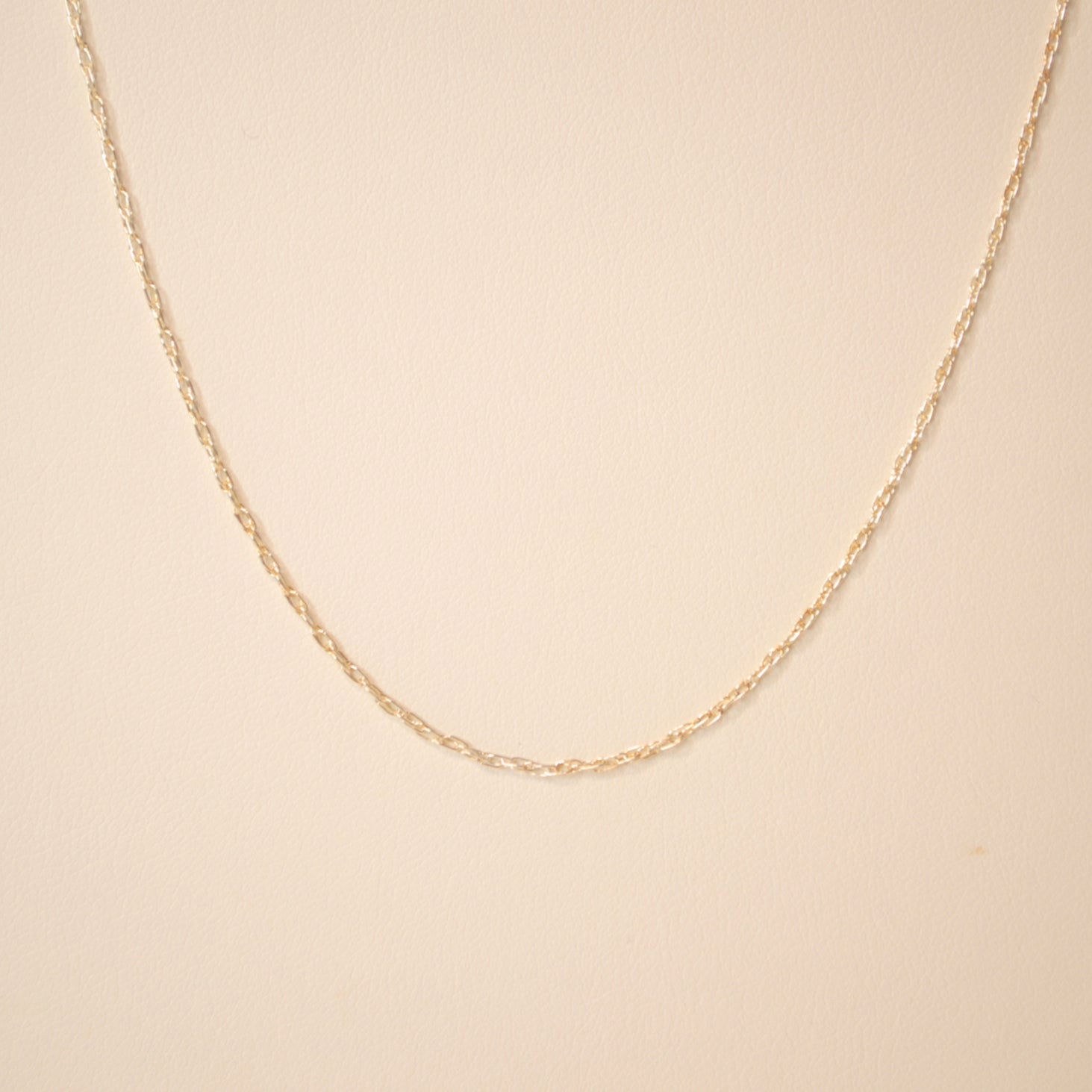 Silver chain against an off white back ground.