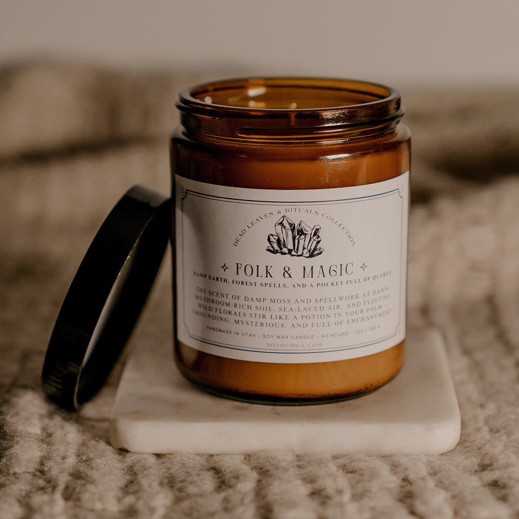 Candle with a label on a marble coaster, blurred background