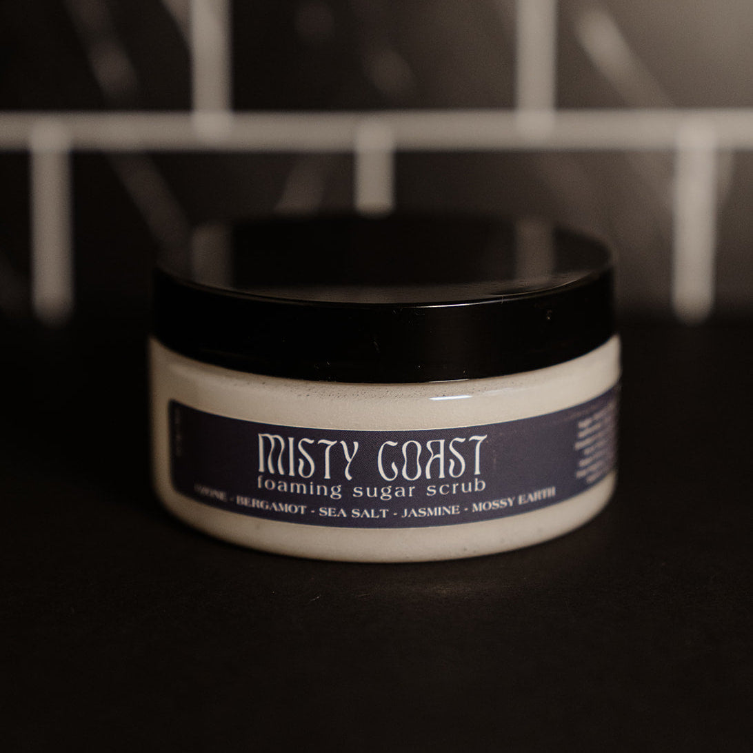 Small clear container with a black lid and navy blue label. Pictured against a black marble back splash.