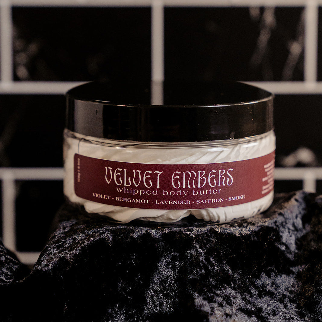 Velvet Embers whipped body butter laying atop a crushed velvet stand. 