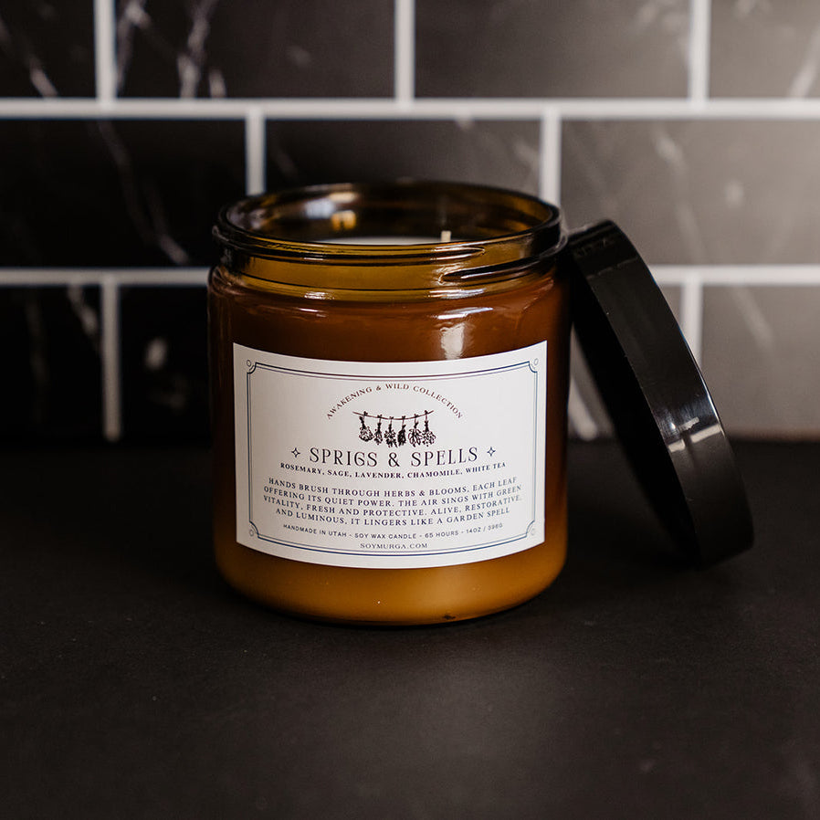 Sprigs & Spells 14 oz candle in an amber glass jar with a double wick. 