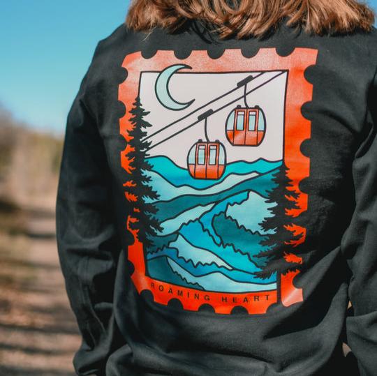 Snowy Sky Lift Daily Long Sleeve featuring a snowy winter landscape with gondalas