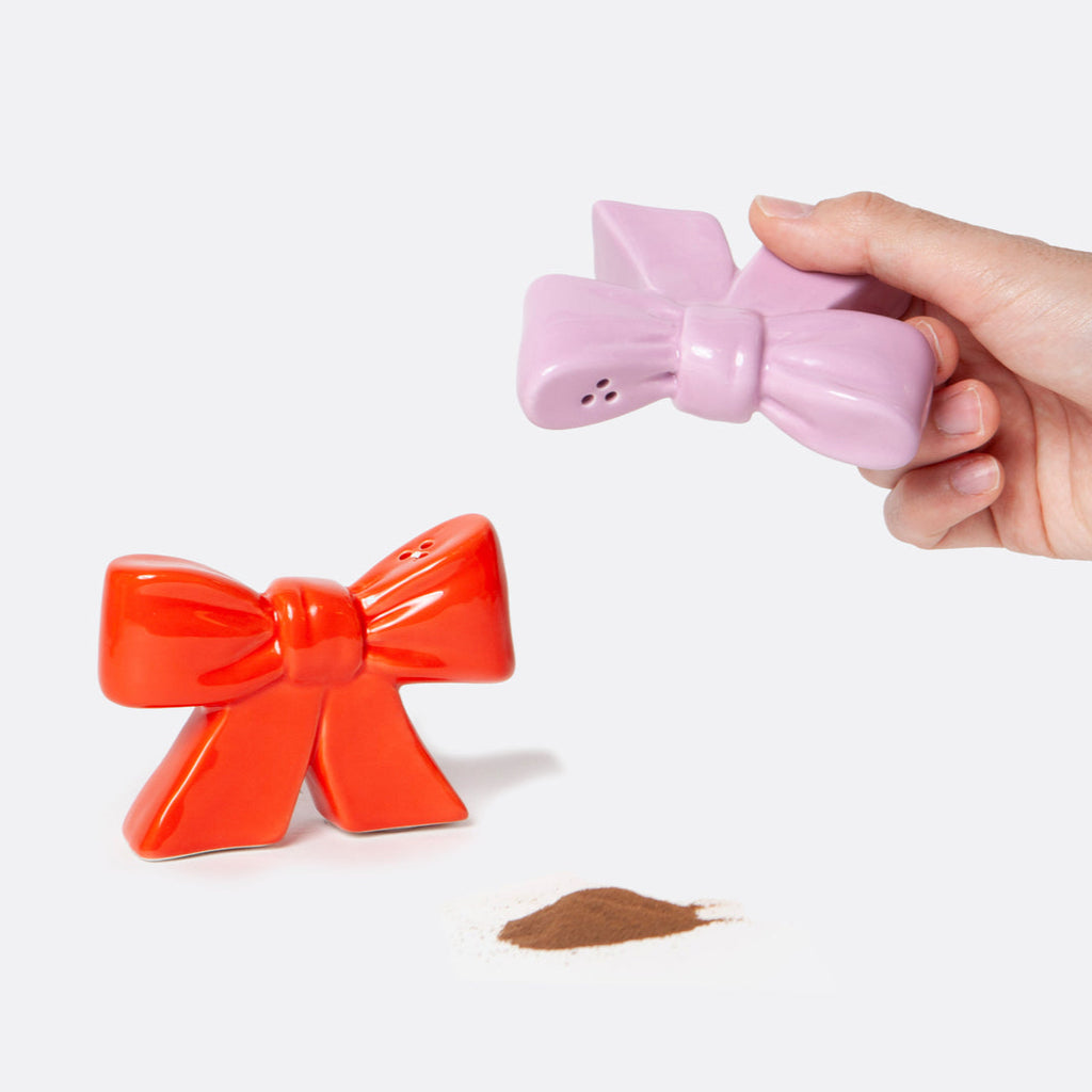 Ceramic salt and pepper shakers shaped as bows, taking inspiration from the ethereal ballet world and the whimsical allure of coquetry.
