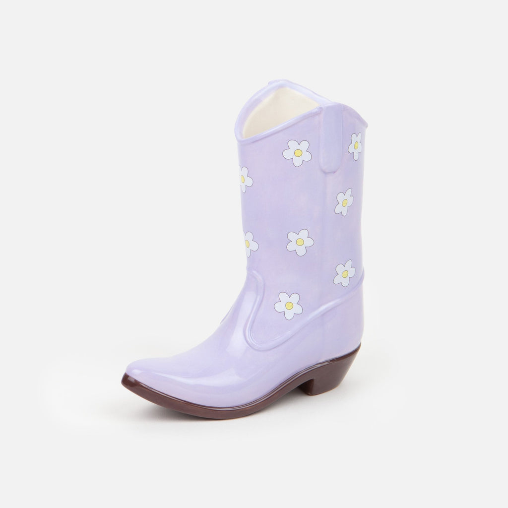 Saddle up and add a touch of whimsy to your home decor with our Lilac Cowboy Boot Vase. This unique boot-shaped vase in a lovely lilac color will add a playful touch to any room, while also providing a stylish way to display your favorite flowers. Giddy up and grab one today!