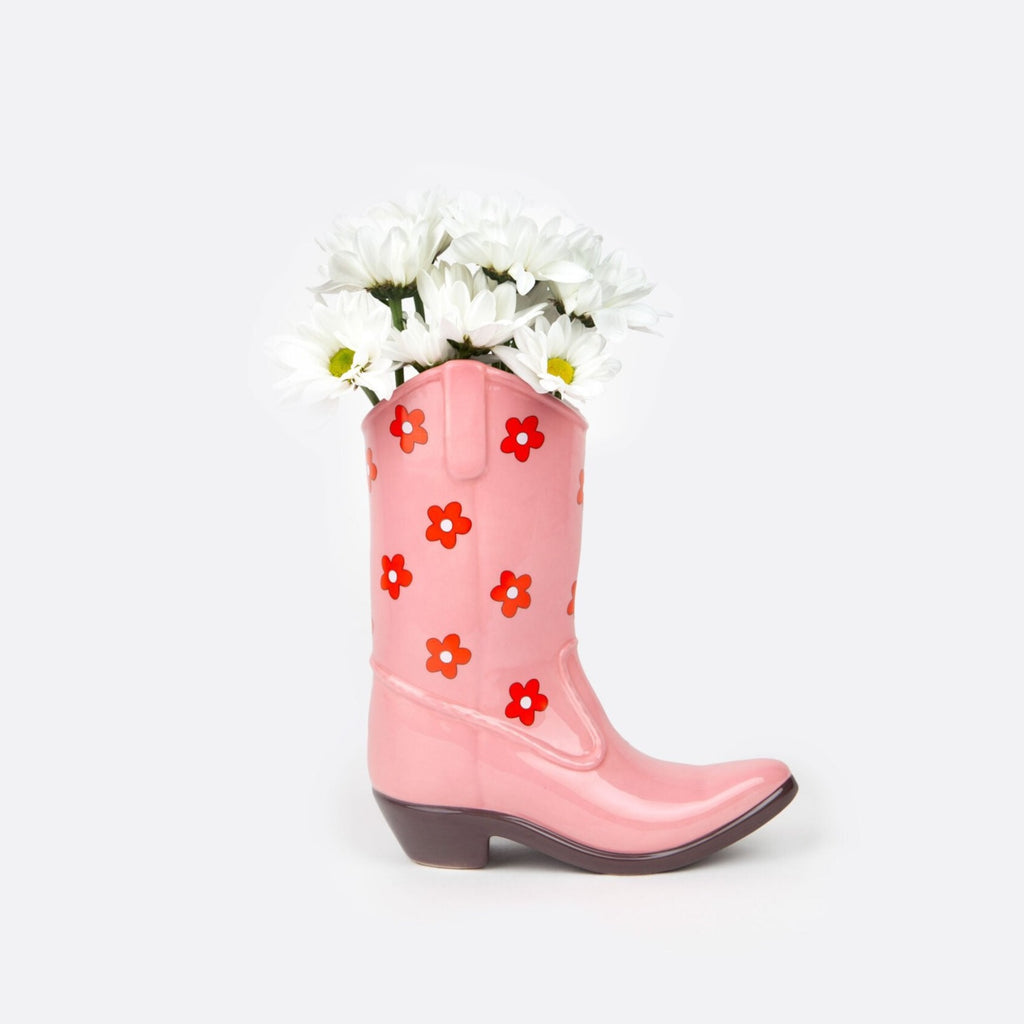 Saddle up and add a touch of whimsy to your home decor with our Pink Cowboy Boot Vase. This unique boot-shaped vase in a lovely lilac color will add a playful touch to any room, while also providing a stylish way to display your favorite flowers. Giddy up and grab one today!