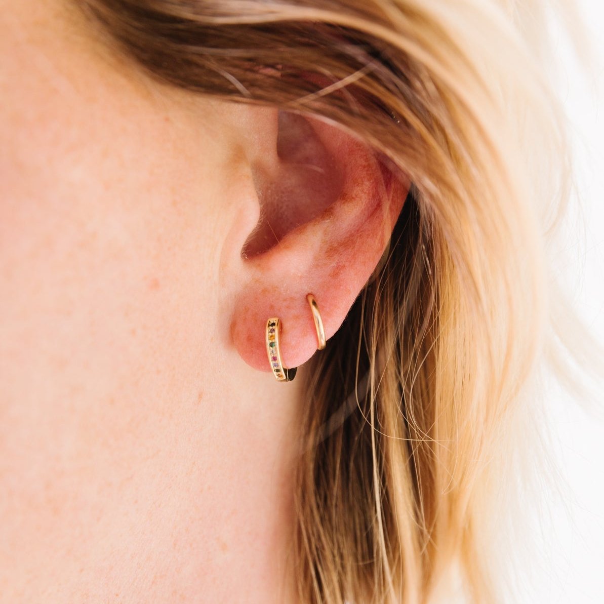 14k Gold Filled 12 mm huggie clasp Safe for sensitive skin Unique clasp has no post when earrings are closed, allowing for comfortable wear and sleep without having to remove earrings Multicolored bejeweld stones&nbsp;are 2 mm Perfect for mulitple piercings Freaking cute and freaking tiny