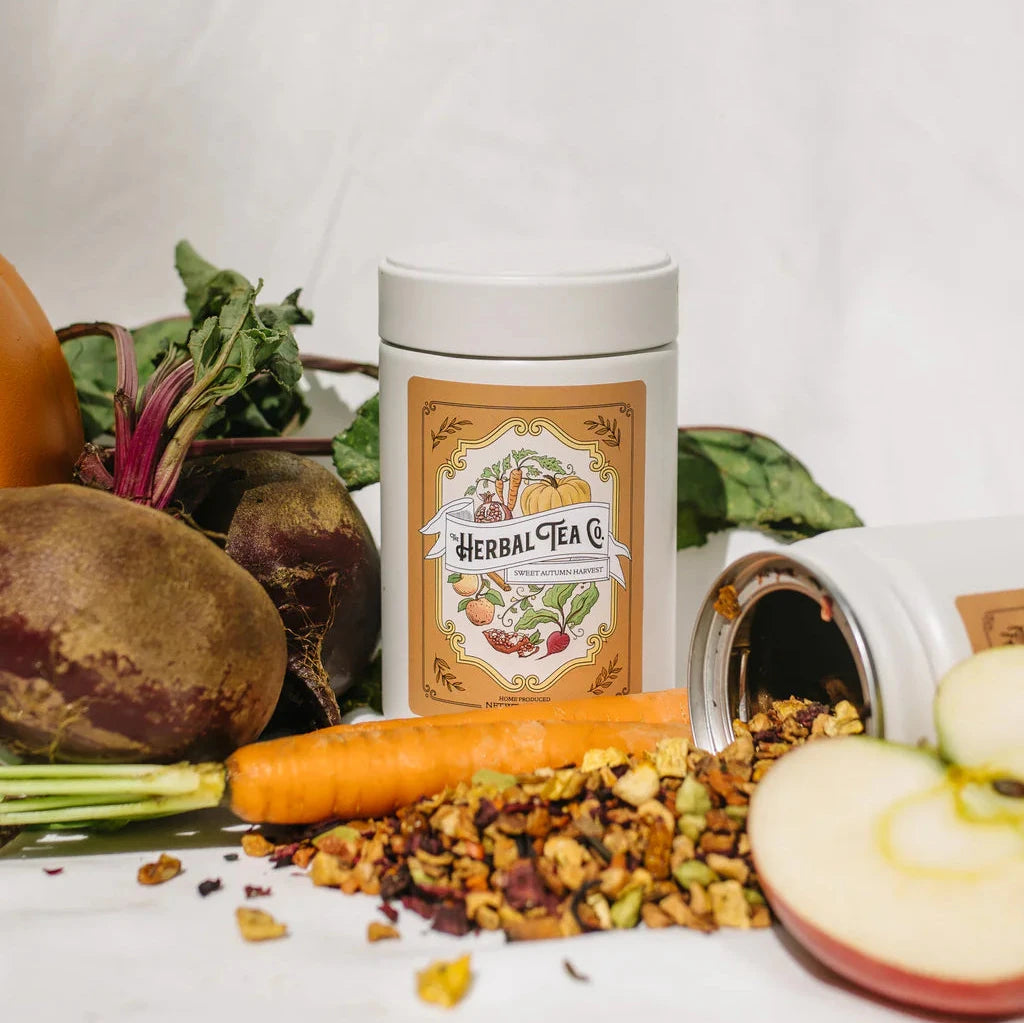 Sweet Autumn Harvest tea tin surrounded by tea, fruits, and vegetables