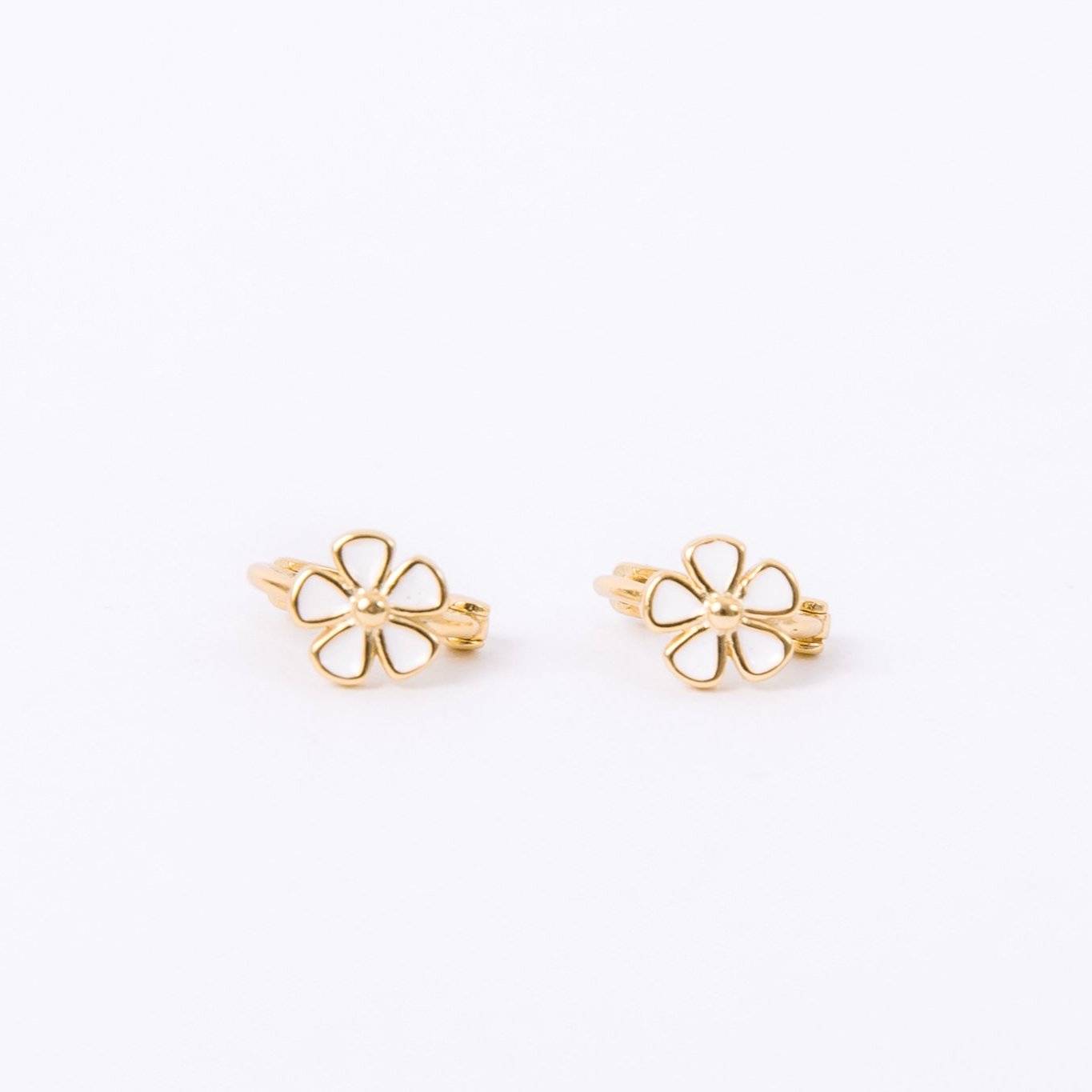 Inset daisy with unique texturing and five tiny enamel petals. Gold huggie hoops