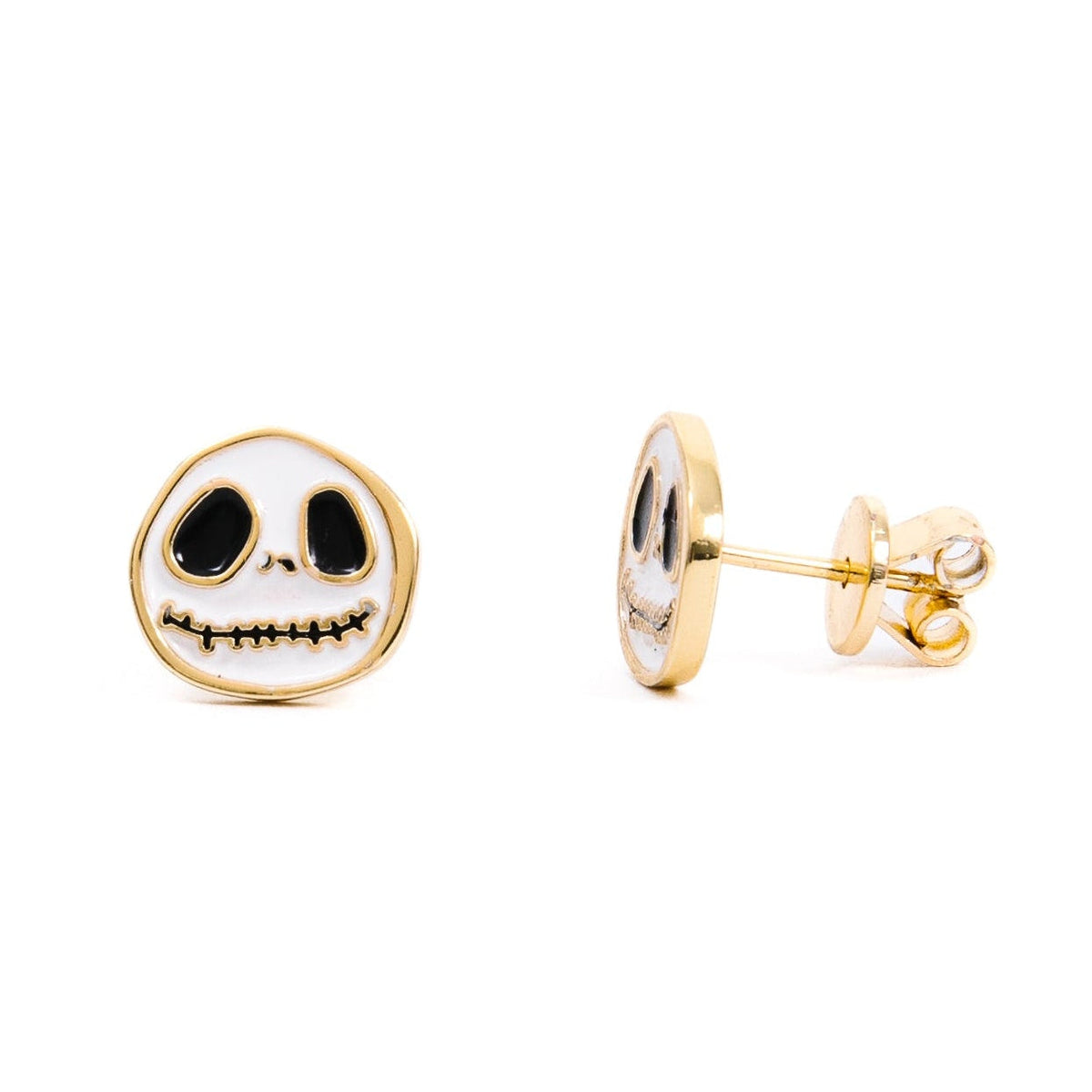 A pair of white and gold skull-inspired stud earrings featuring large black eyes, a small nose, and a stitched black smile, displayed against a white background.
