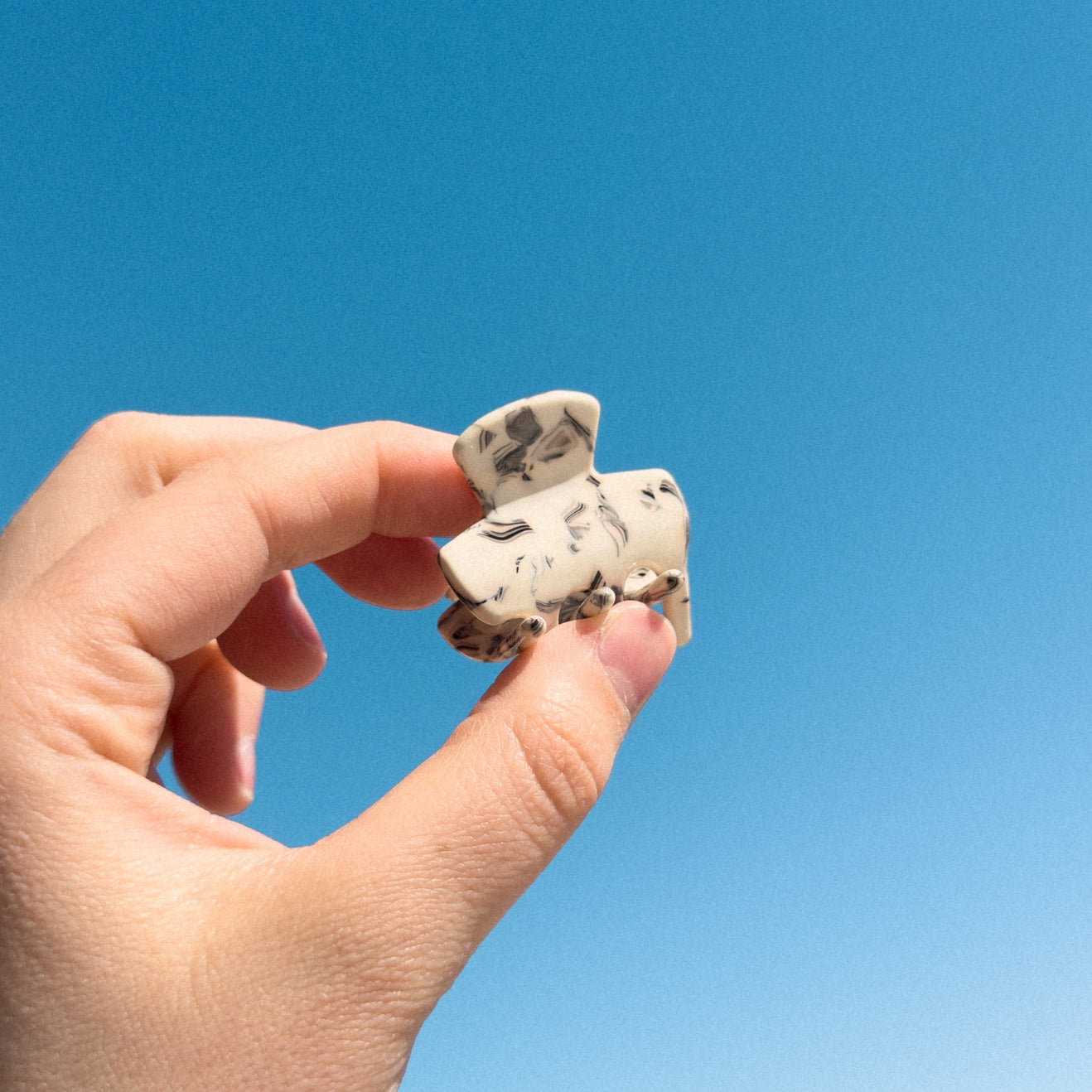 Say hello to our Mini Marble Hair Claw! It's made from eco-friendly acetate, so you can feel good about your purchase. Perfect for everyday wear, this hair claw is both strong and durable, so you don't have to worry about it slipping out of your hair. And because it's small and compact, it's the perfect accessory for those days when you want to add a touch of style without the bulk of a larger hair claw.