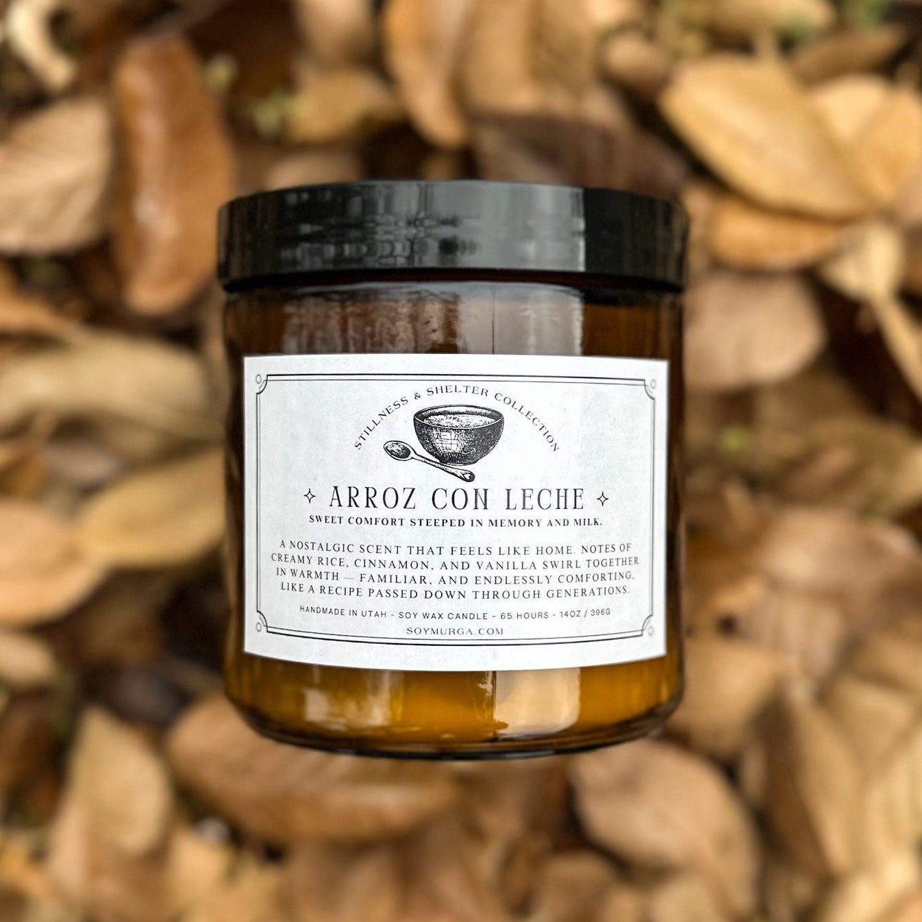 14 oz Arroz Con Leche candle atop a pile of fall leaves. 