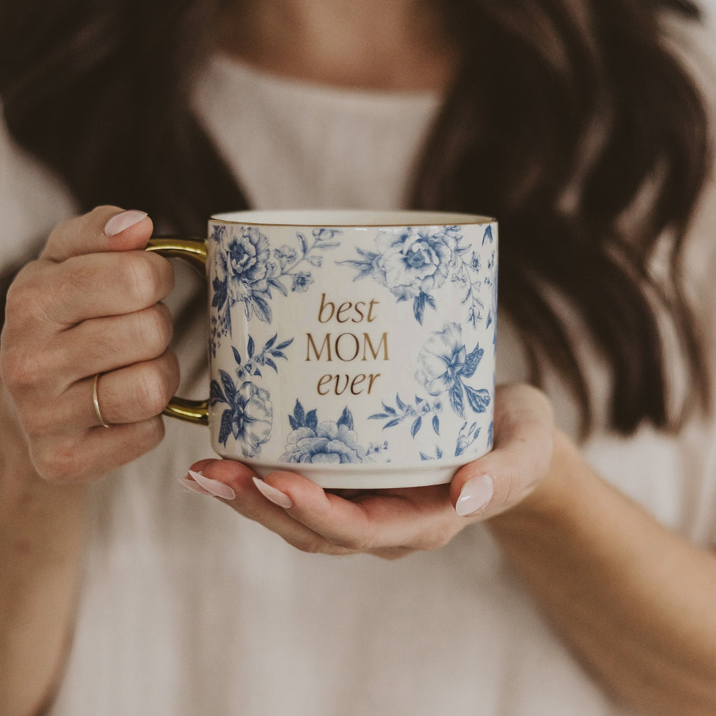 Indulge in your morning ritual with our Love You Stoneware Coffee Mug. Featuring delicate coquette and blue floral designs and a luxurious gold handle, this mug is fit for the best mom ever. Perfect for savoring your favorite brew with a touch of elegance and style.