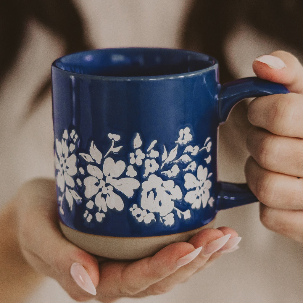 Sip your morning brew in style with our Blue Floral Stoneware Coffee Mug. Featuring a bold blue and delicate white floral design, this stoneware mug adds a touch of elegance to your daily routine. Crafted with durability in mind, it's the perfect way to start your day.