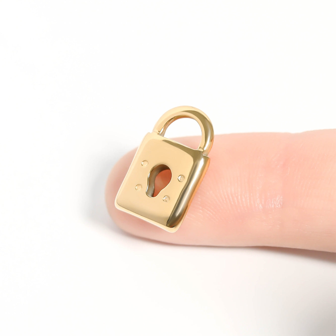 Our 18K Gold PVD Coated Stainless Steel Padlock Charm is the perfect fusion of durability, luxury, and modern design. The padlock charm is a strong, symbolic piece often associated with love, security, and commitment, making it an ideal choice for customers seeking meaningful jewelry. Its sleek, modern design comes in both a gold and stainless steel color.