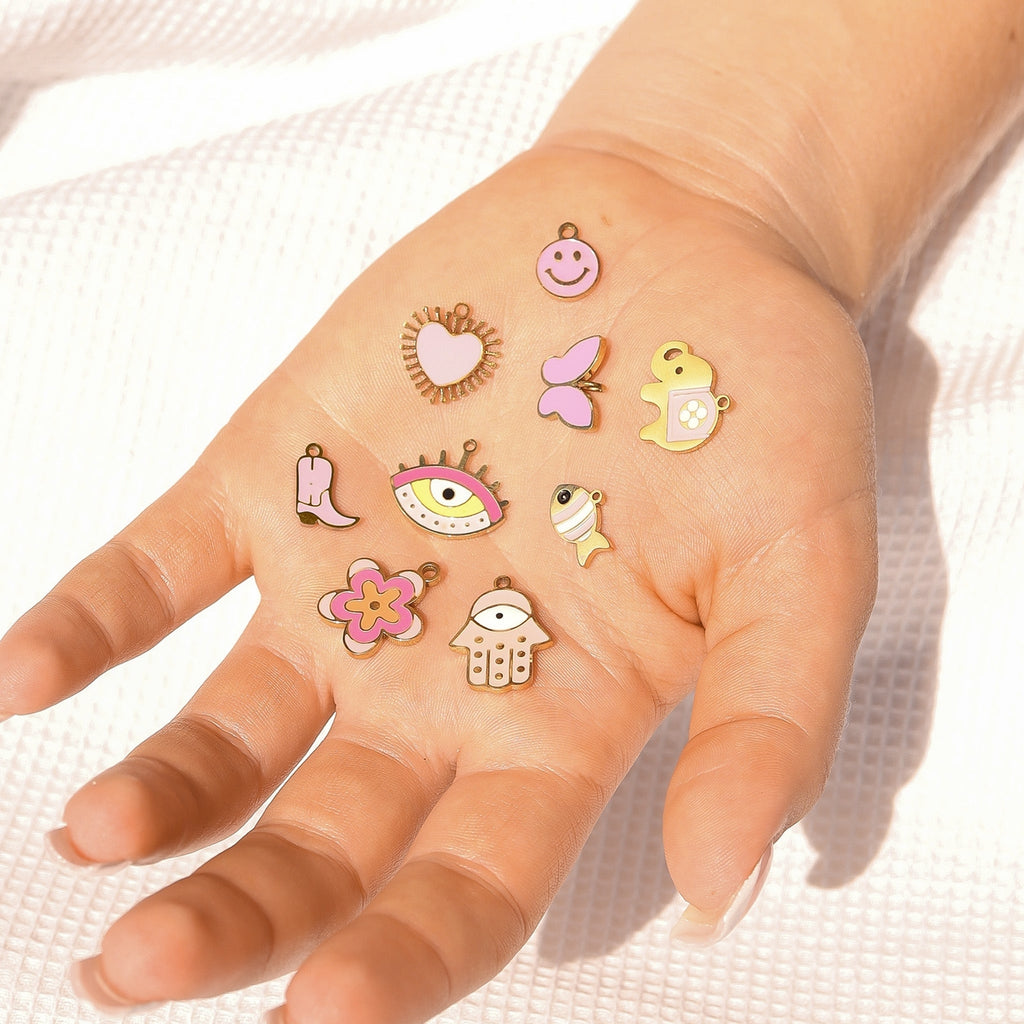Add some playful charm to your look with our 18K Gold Happy Elephant. This quirky, dangling charm features a delightful elephant with blush pink details. Perfect for any occasion, it's sure to make you smile!