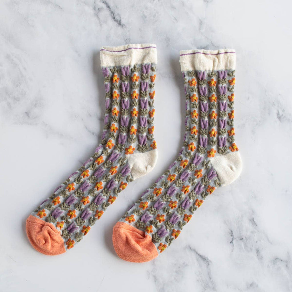 Keep it floral and add some vintage charm to your sock game with these adorable crew socks. Made from soft, durable material, these socks feature a dainty floral pattern in beige and coral. Perfect for adding a touch of whimsy to any outfit.