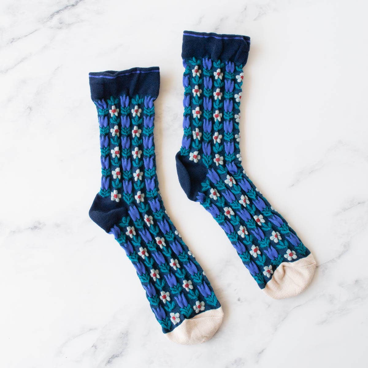 Keep it floral and add some vintage charm to your sock game with these adorable crew socks. Made from soft, durable material, these socks feature a dainty floral pattern in various shades of blue. Perfect for adding a touch of whimsy to any outfit.