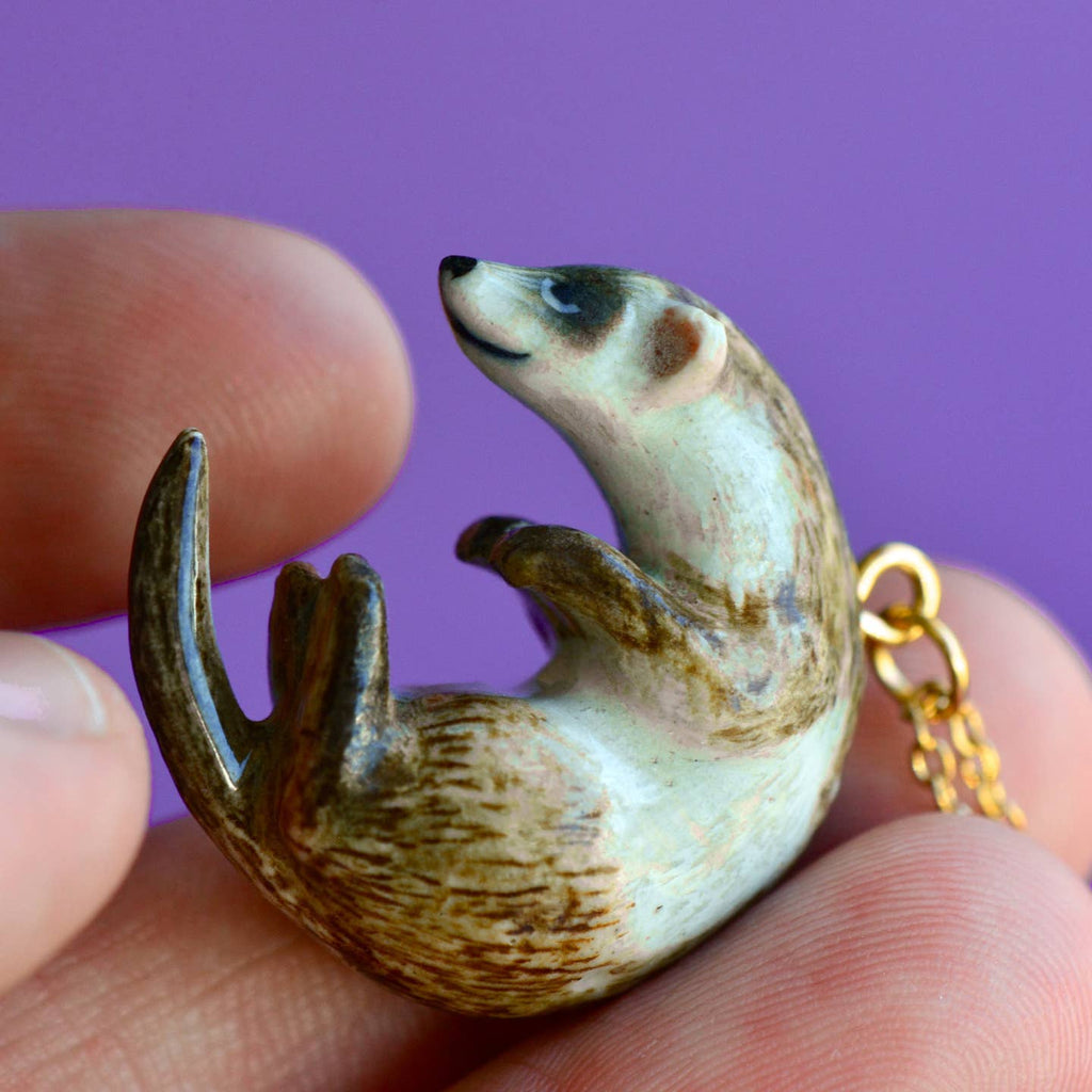 Add a dash of whimsy and historical charm to your style with our Ferret Necklace! Celebrating a creature that has captivated everyone from Aristotle to Queen Elizabeth I, this hand-painted pendant captures the ferret's playful essence in a pose that's as zany as it is adorable. This versatile necklace is a delightful addition to any outfit, whether you're keeping it casual or dressing to impress. Due to the handmade nature of this product, slight variations in color and design may occur.