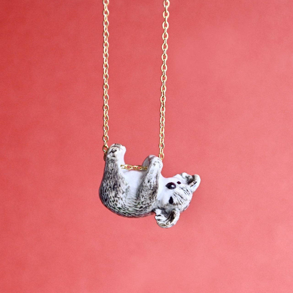 From the eucalyptus groves of Australia to your jewelry box comes our handcrafted Koala Necklace. This porcelain pendant captures the essence of this beloved marsupial, known for its relaxed demeanor and love of leafy snacks. Each piece comes with a special stamp of authenticity and is strung on a 24-inch 24k gold steel chain. Due to the handmade nature of this product, slight variations in color and design may occur, making each piece truly one-of-a-kind.