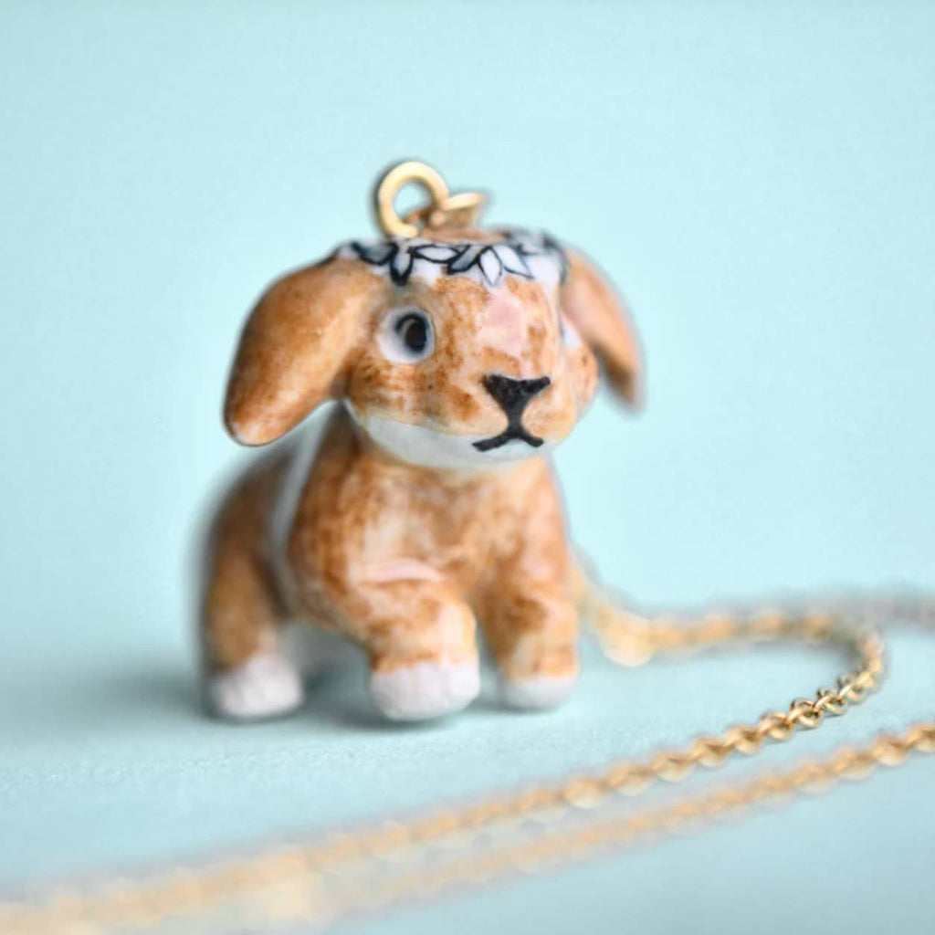 Leap into the joys of the season with our limited-edition Spring Bunny Necklace! This handcrafted porcelain pendant captures the essence of springtime, featuring a sprightly bunny that's as adorable as it is symbolic of new beginnings. Strung on a delicate chain, this necklace is a versatile and uplifting addition to any ensemble, from casual daywear to elegant Easter gatherings. Due to the handmade nature of this product, slight variations in color and design may occur, making each piece truly unique.