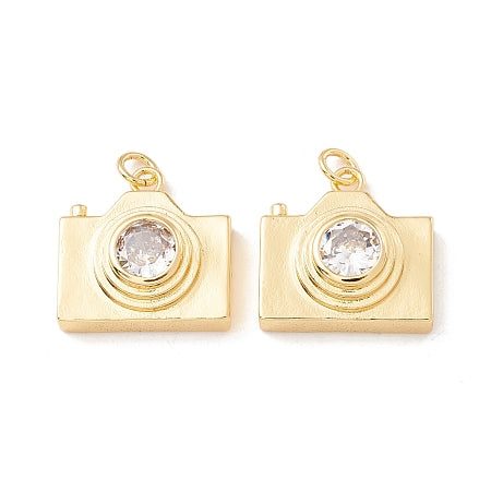 Capture life's precious moments with our Gold Camera Charm. This dainty charm can be worn on a bracelet or necklace, and features intricate cubic zirconia detailing for a touch of sparkle. Its beautiful gold color adds a touch of elegance to any outfit. A must-have for any photography enthusiast!