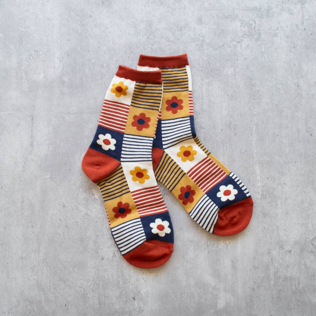 Step up your sock game with our Daisy Brick &amp; Navy Multi Striped Socks. The perfect combination of style and comfort, these crew socks feature a playful daisy and striped design in classic brick and navy colors. Elevate any outfit with these fun and fashionable socks.